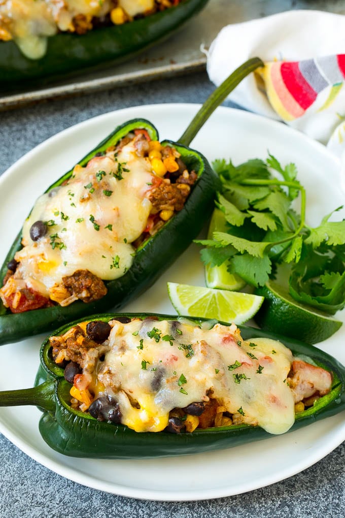 Stuffed Poblano Peppers | Stuffed Peppers | Pasilla Peppers #peppers #stuffedpeppers #beef #rice #beans #corn #dinner #uzhal A plate of stuffed poblano peppers topped with melted cheese.