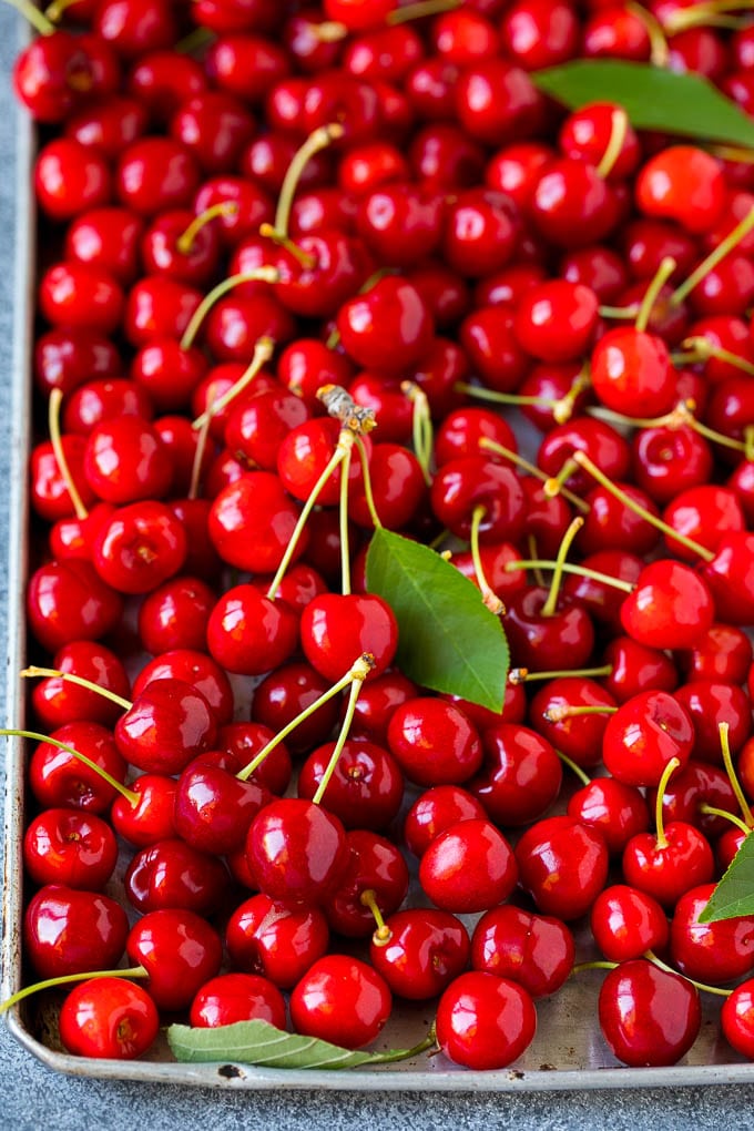 Cherry Pie Filling Recipe #pie #cherries #dessert #sweets #uzhal #summer Fresh cherries spread out on a sheet pan.