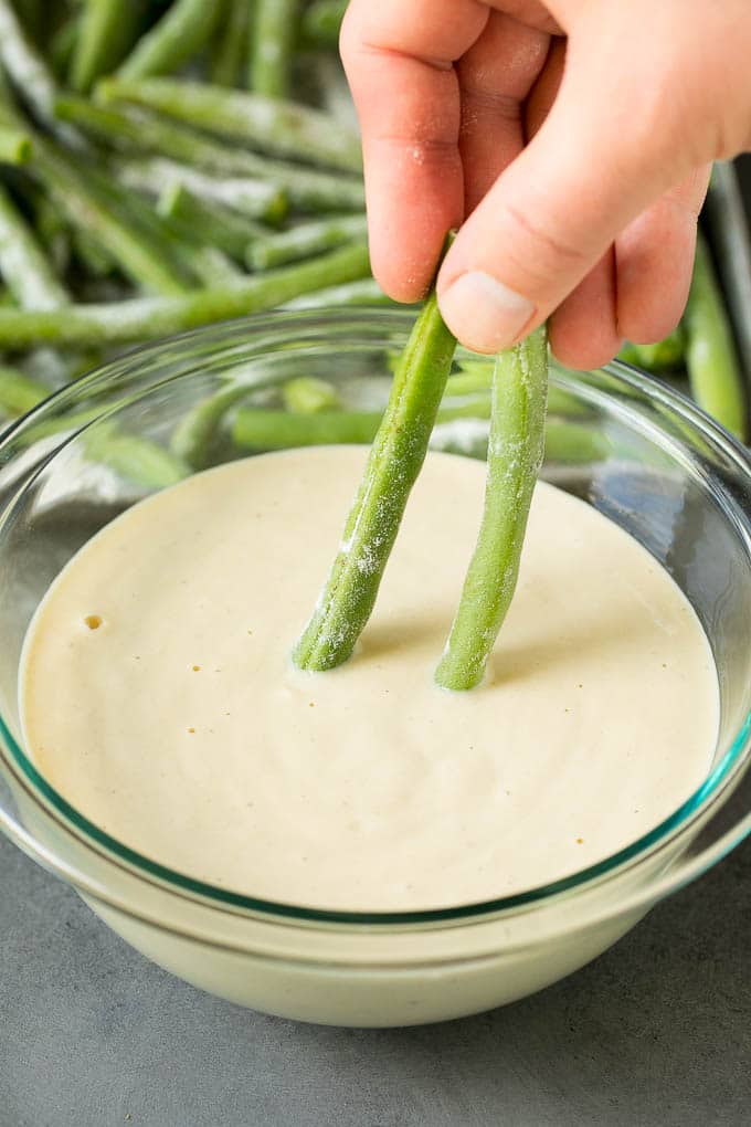 Fried Green Beans Recipe | Green Beans #greenbeans #appetizer #snack #uzhal A hand dipping beans into beer batter.