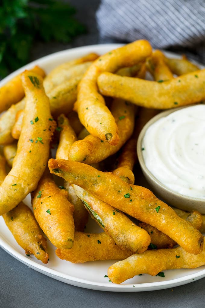 Fried Green Beans Recipe | Green Beans #greenbeans #appetizer #snack #uzhal A plate of fried green beans served with ranch dip.