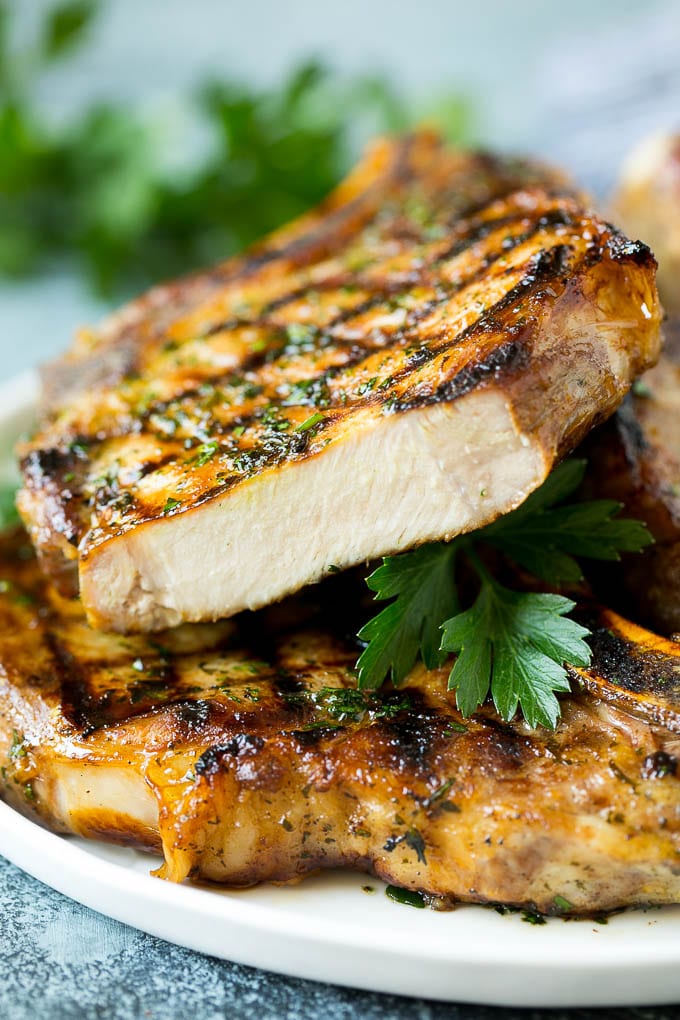Grilled Pork Chops | Pork Chop Marinade #porkchops #grilling #pork #marinade #dinner #uzhal Grilled pork chops with a cut chop on top of the stack.