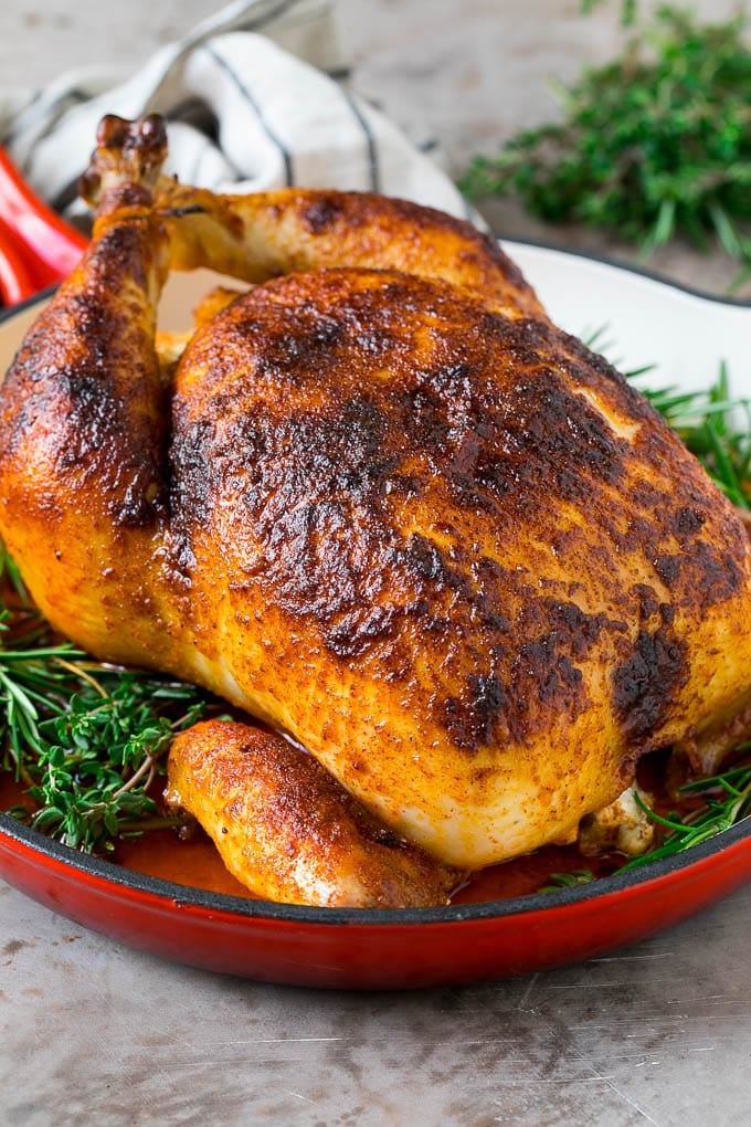 Rotisserie Chicken Recipe | Roasted Chicken #chicken #dinner #uzhal #comfortfood Rotisserie chicken in a skillet garnished with fresh herbs.