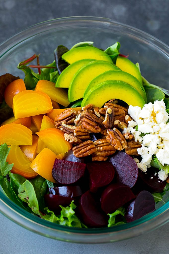 Beet Salad Recipe #beets #avocado #feta #salad #dinner #uzhal Red and yellow beets, salad greens, feta cheese, avocado and pecans in a bowl.