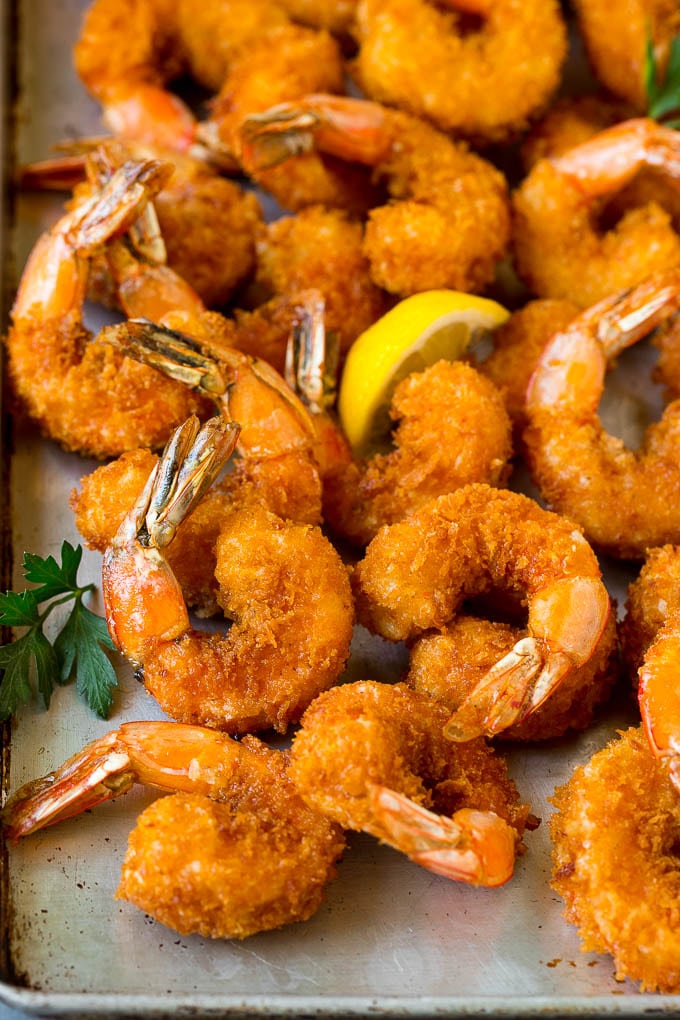 Fried Shrimp Recipe #shrimp #seafood #dinner #appetizer #uzhal Fried shrimp on a sheet pan garnished with parsley and lemon.