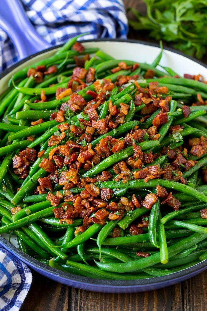 Green Beans with Bacon Recipe | Bacon Green Beans #bacon #greenbeans #sidedish #thanksgiving #veggies #dinner #uzhal Green beans with bacon in a skillet, topped with parsley.