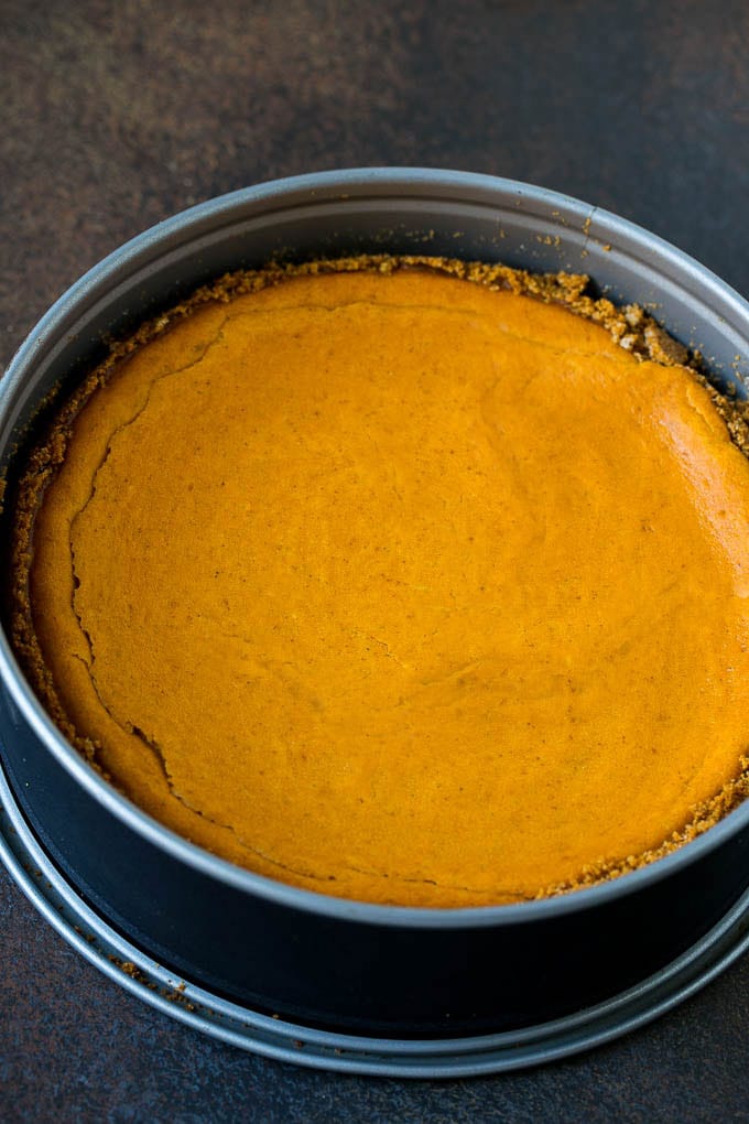 Pumpkin Pie Cheesecake Recipe | Pumpkin Cheesecake #cake #cheesecake #pumpkin #fall #thanksgiving #dessert #uzhal A baked pumpkin cheesecake in a pan.