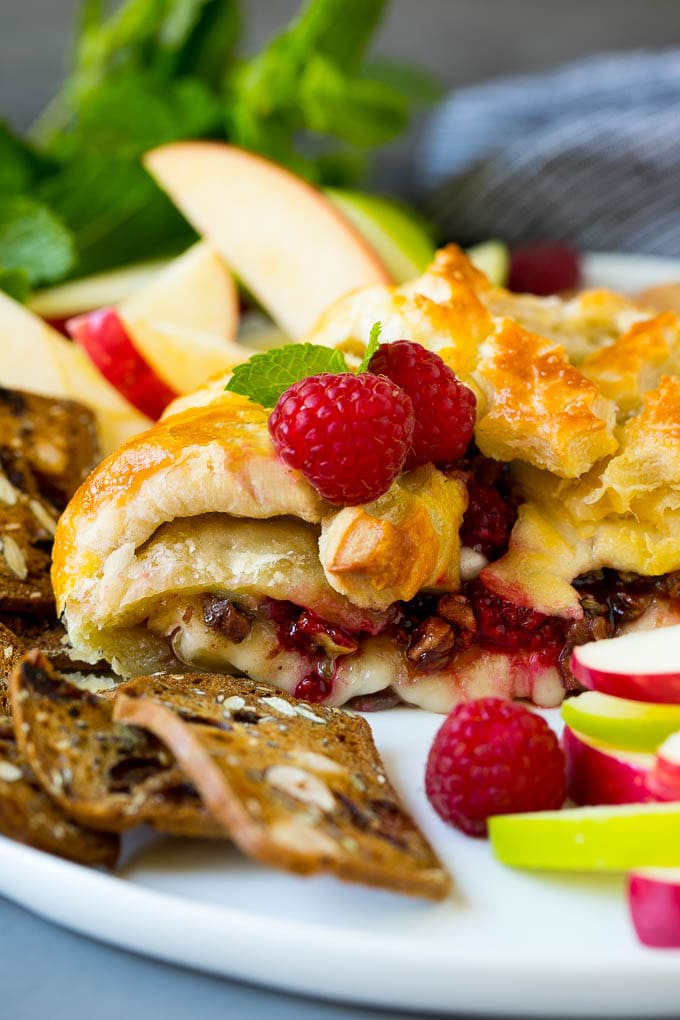 Baked Brie Recipe | Pastry Wrapped Brie #brie #cheese #appetizer #pecans #raspberries #uzhal A cross section of baked brie filled with raspberries and pecans.