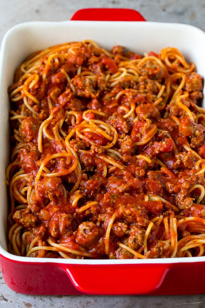 Pasta tossed with meat sauce in a dish.
