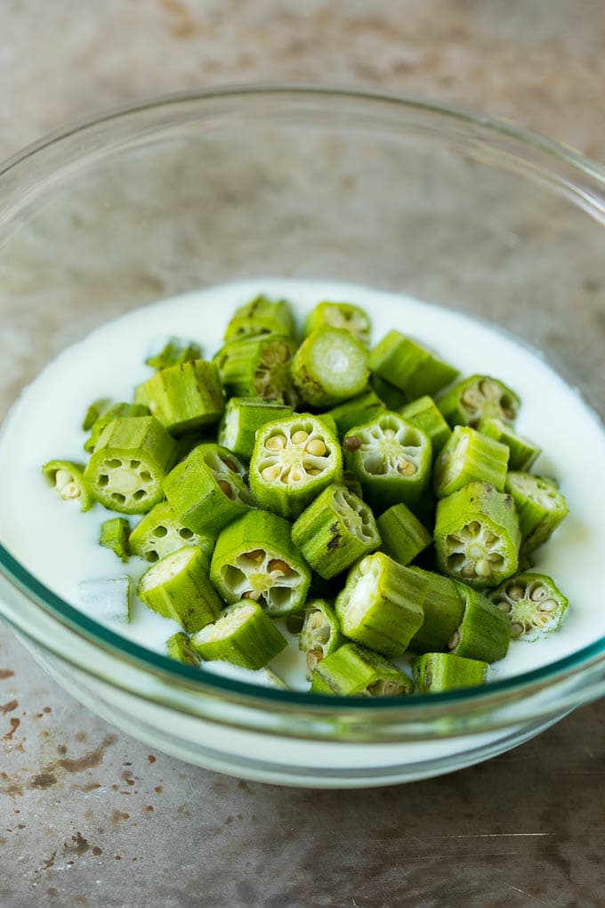 Fried Okra Recipe #okra #appetizer #sidedish #uzhal Sliced okra in a bowl of buttermilk.