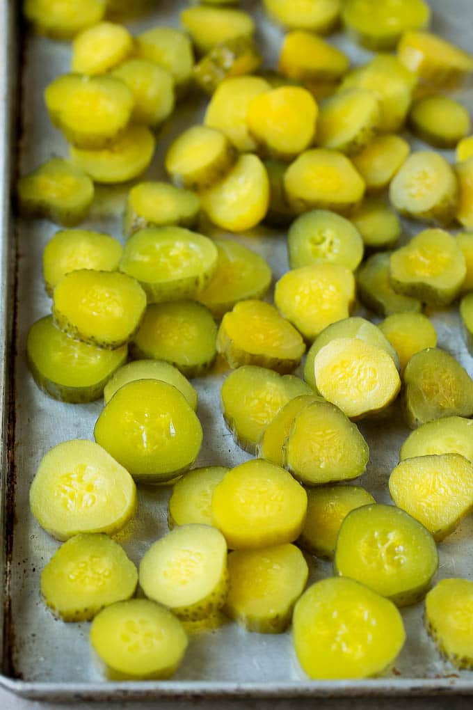 Fried Pickles Recipe #pickles #appetizer #snack #uzhal Sliced dills on a sheet pan.