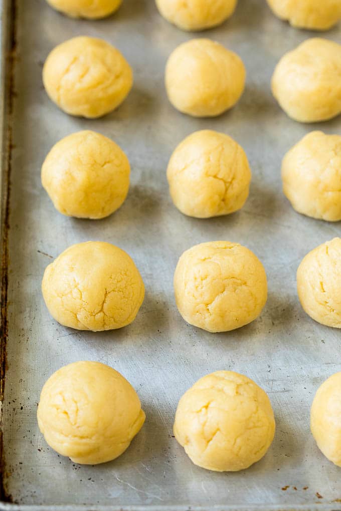 Italian Cookies Recipe | Almond Cookies #cookies #italianfood #frosting #sprinkles #baking #christmas #uzhal Balls of cookie dough on a sheet pan.