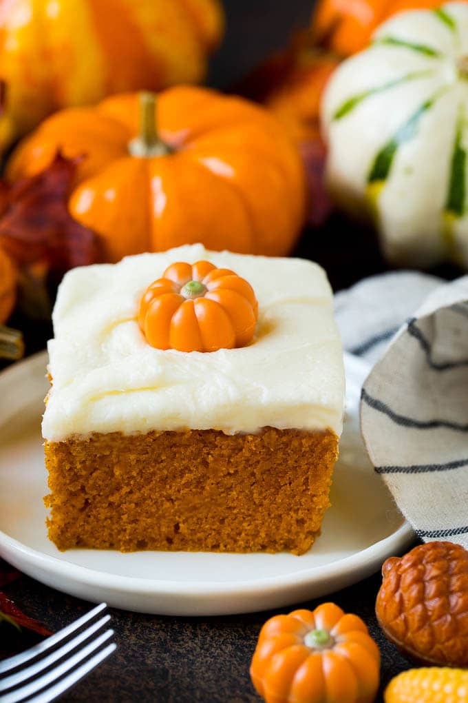 Pumpkin Cake Recipe | Pumpkin Spice Cake #cake #pumpkin #dessert #baking #fall #thanksgiving #uzhal A slice of pumpkin cake topped with cream cheese frosting.