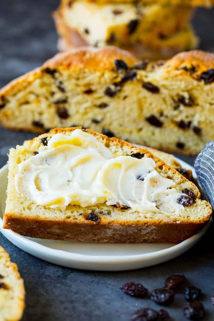 Irish Soda Bread Recipe #bread #baking #stpatricksday #sidedish #uzhal A slice of Irish soda bread with butter spread on it.