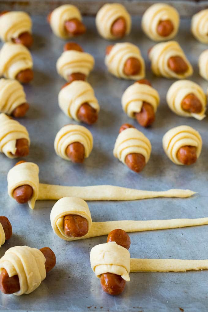 Pigs in a Blanket Recipe #hotdogs #appetizer #snack #comfortfood #uzhal Hot dogs being rolled up in dough.
