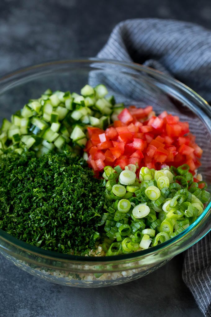 Tabbouleh Salad | Tabouli #salad #wheat #tomatoes #cucumber #healthy #sidedish #dinner #uzhal A bowl of bulgur topped with herbs, tomatoes and cucumber.