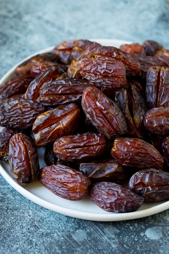 Bacon Wrapped Dates #appetizer #bacon #dates #cheese #uzhal Dates split open on a plate.