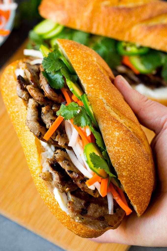 Bahn Mi Sandwich Recipe #sandwich #pork #lunch #dinner #uzhal A hand holding a pork banh mi sandwich.