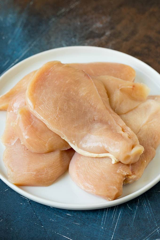 Chicken Francese Recipe #chicken #lemon #dinner #uzhal Thin cut chicken breasts on a plate.