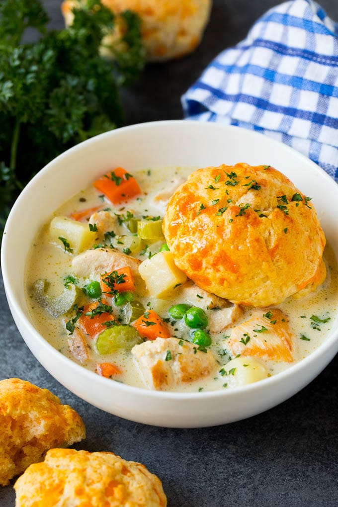 Chicken Pot Pie Soup Recipe | Chicken Soup #soup #chicken #dinner #comfortfood #uzhal A bowl of chicken pot pie soup with a biscuit on top.