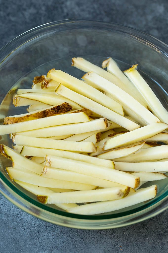 Homemade French Fries Recipe #potatoes #fries #dinner #uzhal Sliced potato sticks in a bowl of water.