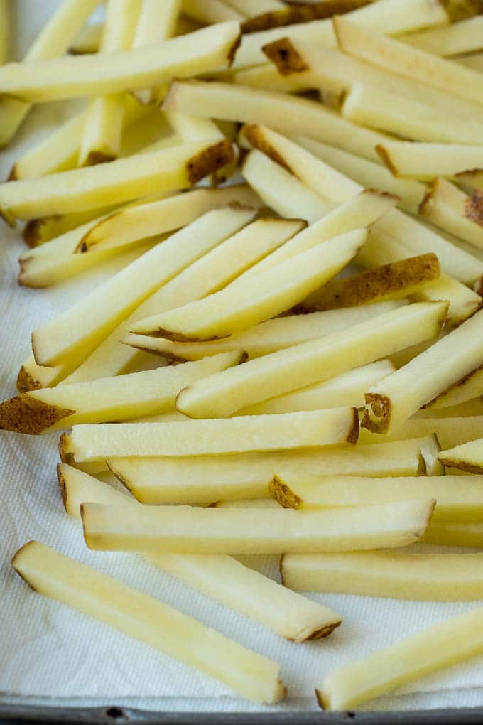 Homemade French Fries Recipe #potatoes #fries #dinner #uzhal Potatoes cut into fry shapes on a paper towel lined pan.