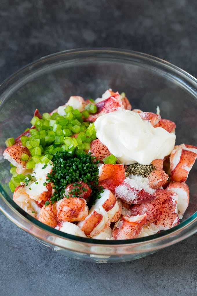 Lobster rolls stuffed with creamy lobster salad in a toasted bun. #lobster #uzhal Lobster, chives, celery and mayonnaise in a bowl.