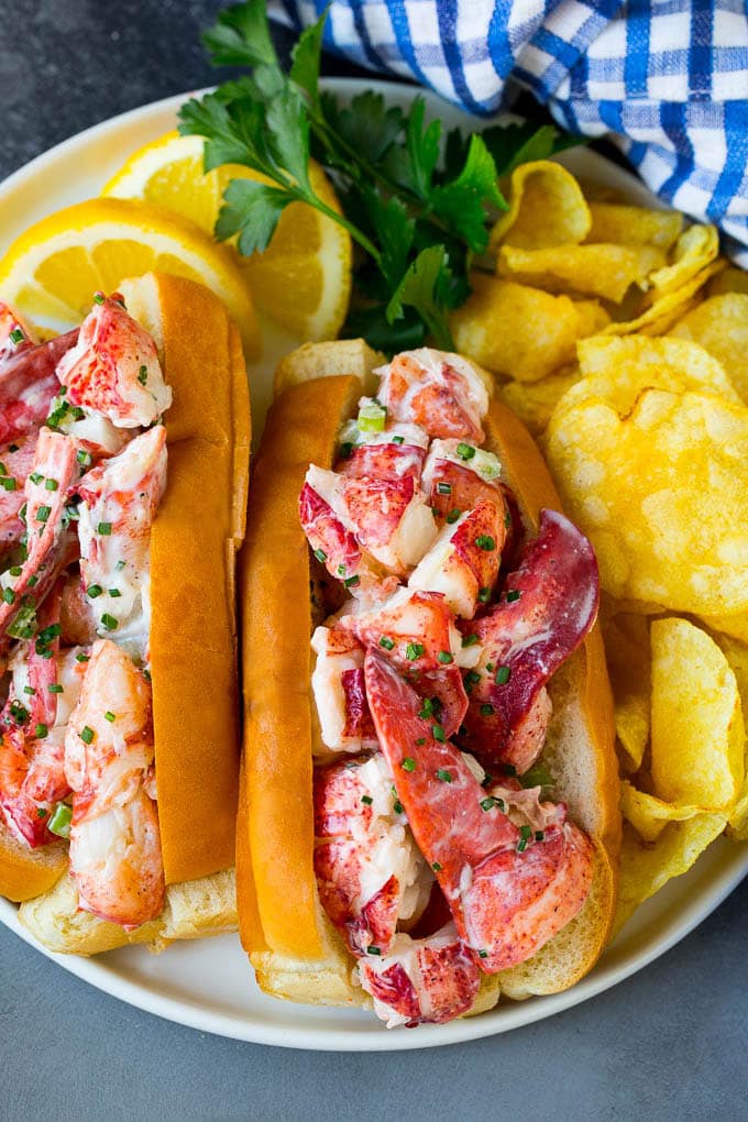 Lobster rolls stuffed with creamy lobster salad in a toasted bun. #lobster #uzhal A lobster roll filled with a creamy seafood mixture and served with chips.