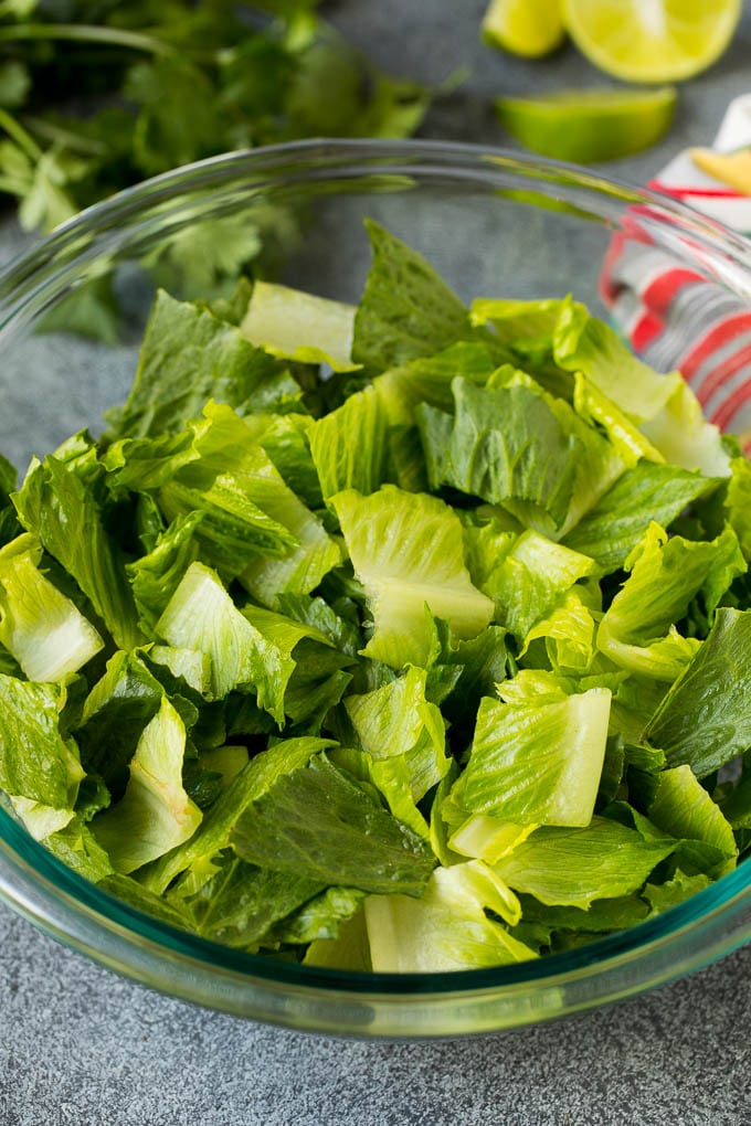 Mexican Salad Recipe #salad #corn #beans #avocado #tomatoes #uzhal Chopped romaine lettuce in a bowl.