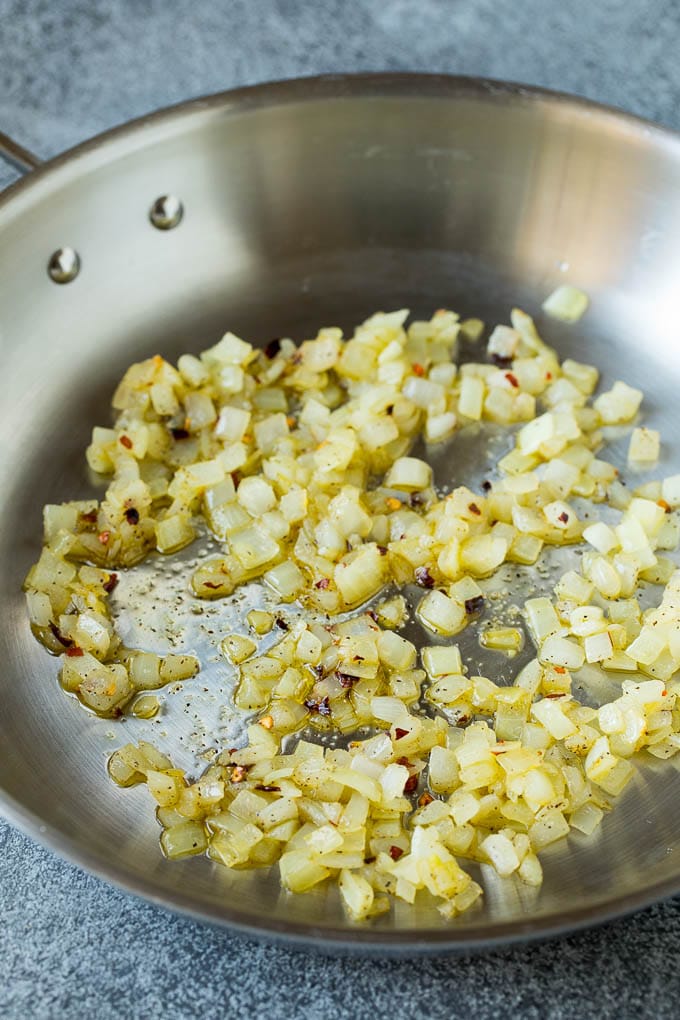 Sauteed kale flavored with olive oil and garlic, a quick and easy side dish! #kale #uzhal Sauteed onions in a skillet.