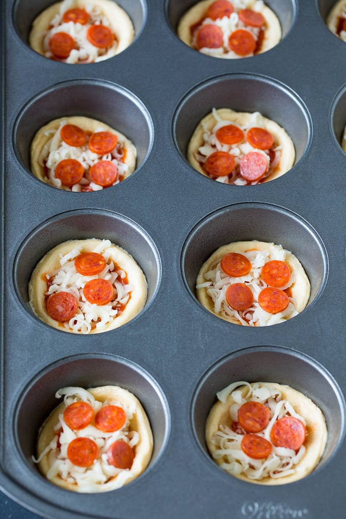 Mini pizzas topped with pepperoni are a fun and easy appetizer option. #pizza #uzhal #appetizer Dough topped with sauce, cheese and mini pepperoni.
