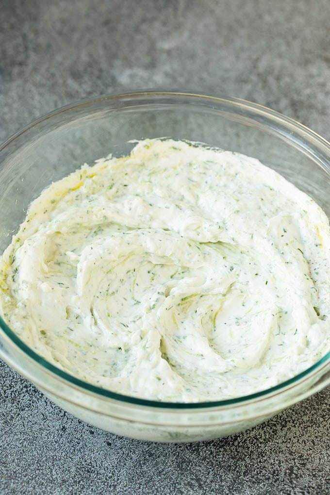 The best homemade tzatziki sauce with cucumber and herbs mixed into Greek yogurt. #appetizer #uzhal Tzatziki sauce in a glass bowl.