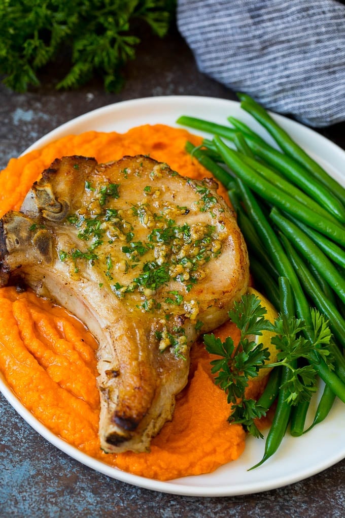 Meat served with sweet potatoes and green beans.