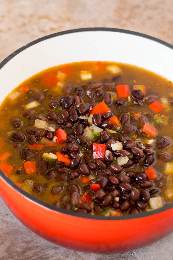 A pot of beans, broth and vegetables.