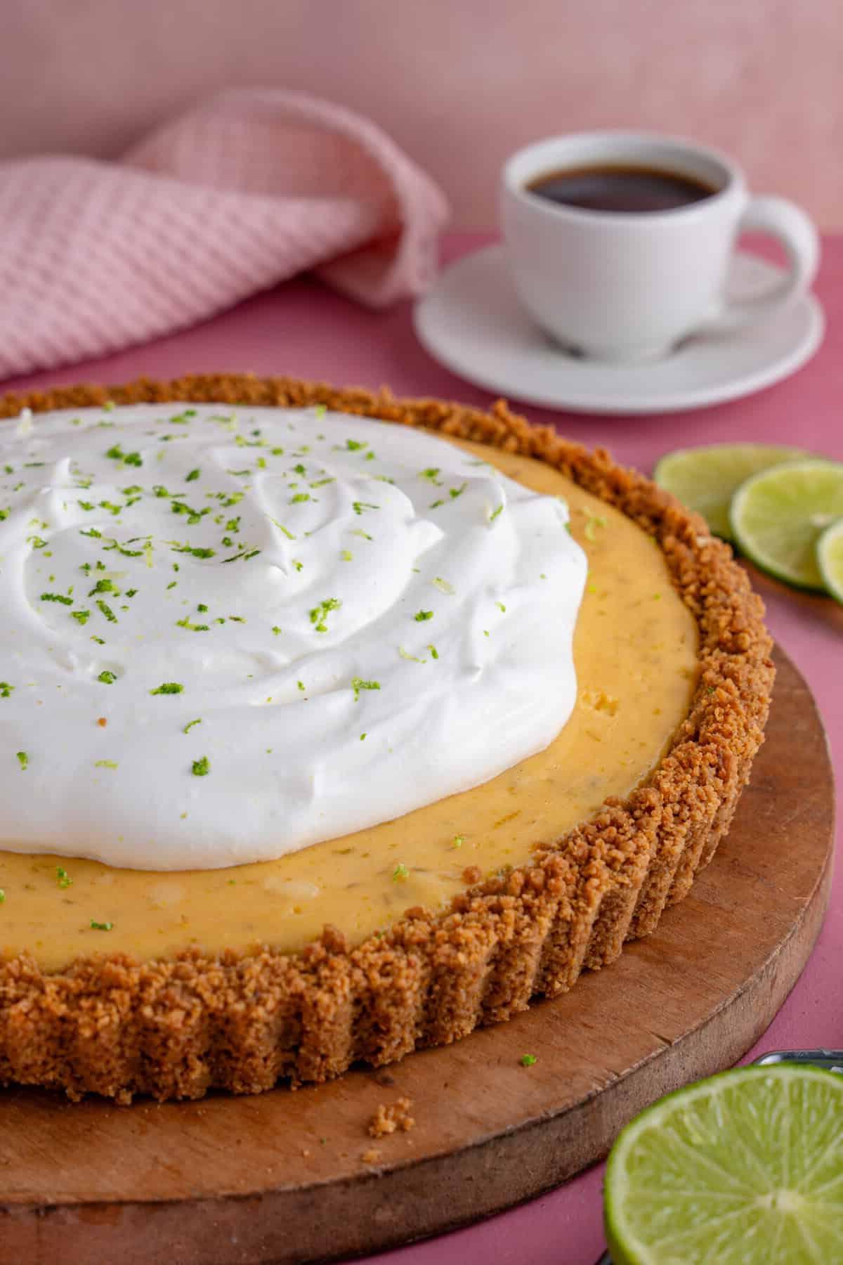 Torta al Lime Senza Glutine 2 Una Torta Key Lime senza glutine con una base di biscotti, ripieno al lime e panna montata sopra.