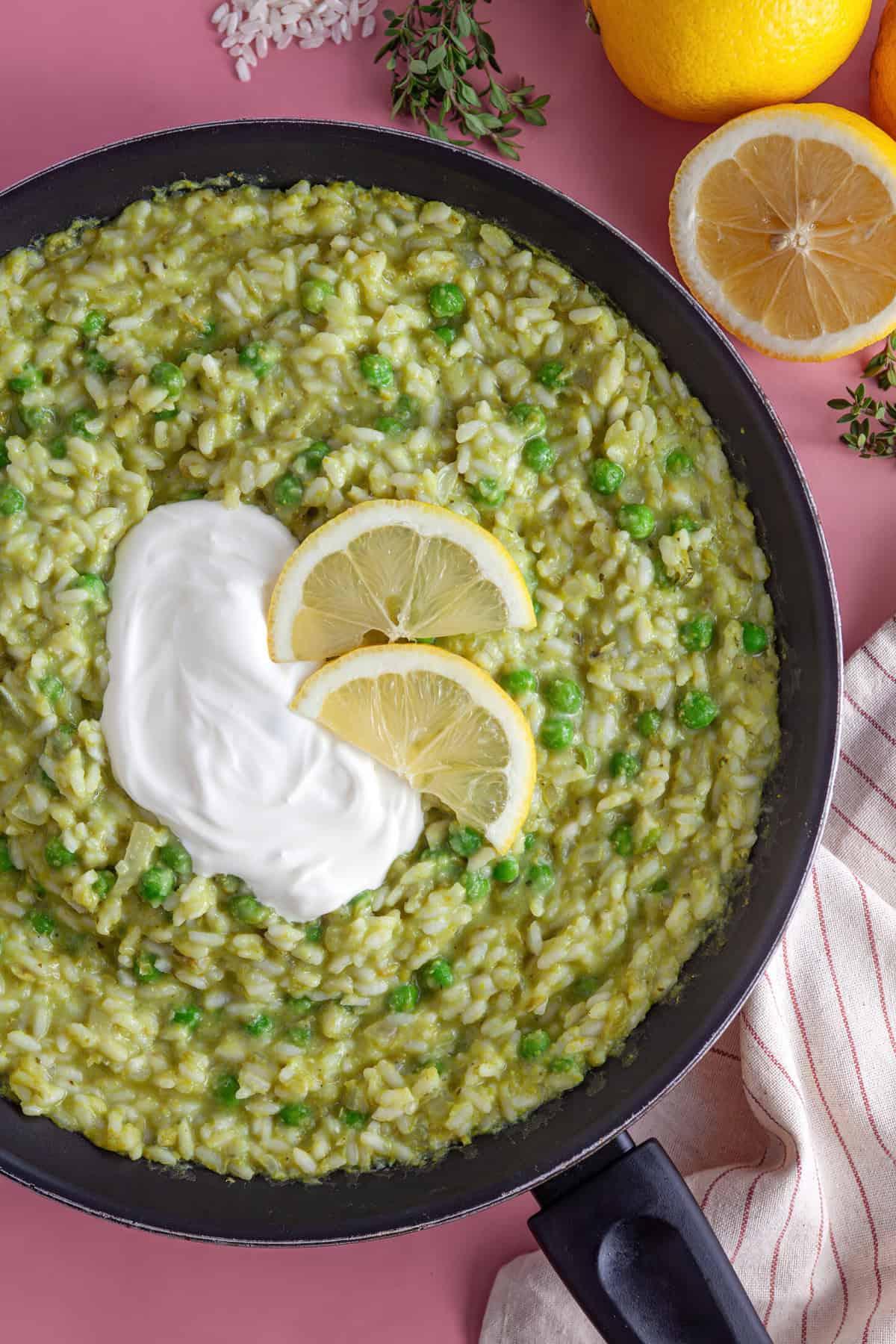 Risotto di Piselli 2 Una padella di risotto ai piselli con crème fraîche e limone sopra.
