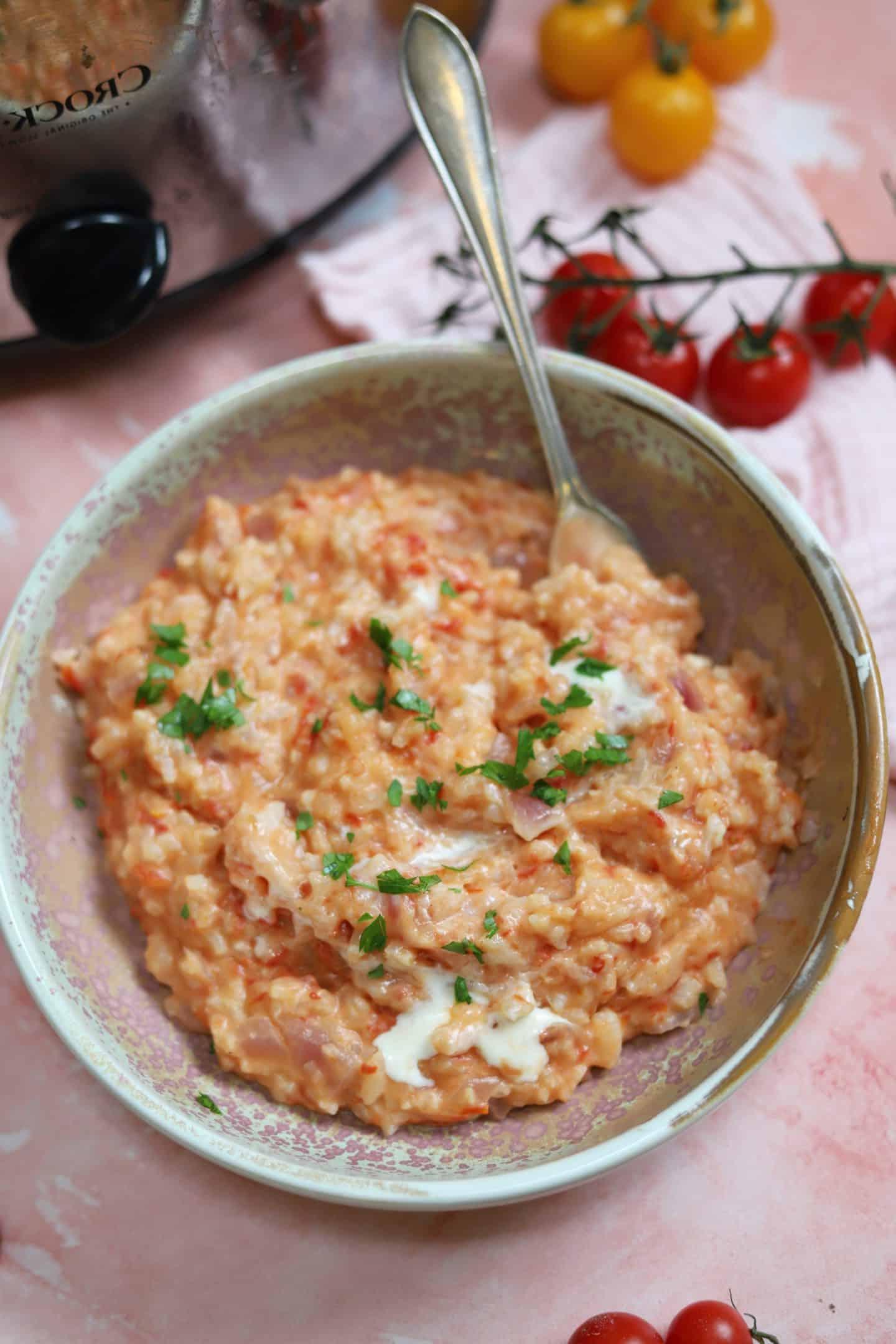 Risotto al Pomodoro e Mascarpone 2 Una ciotola fumante di risotto al pomodoro e mascarpone, adornata con erbe fresche, pronta per essere gustata.