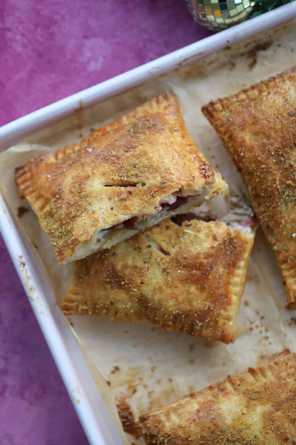 Una torta salata natalizia senza glutine tagliata a metà, su una teglia da forno.