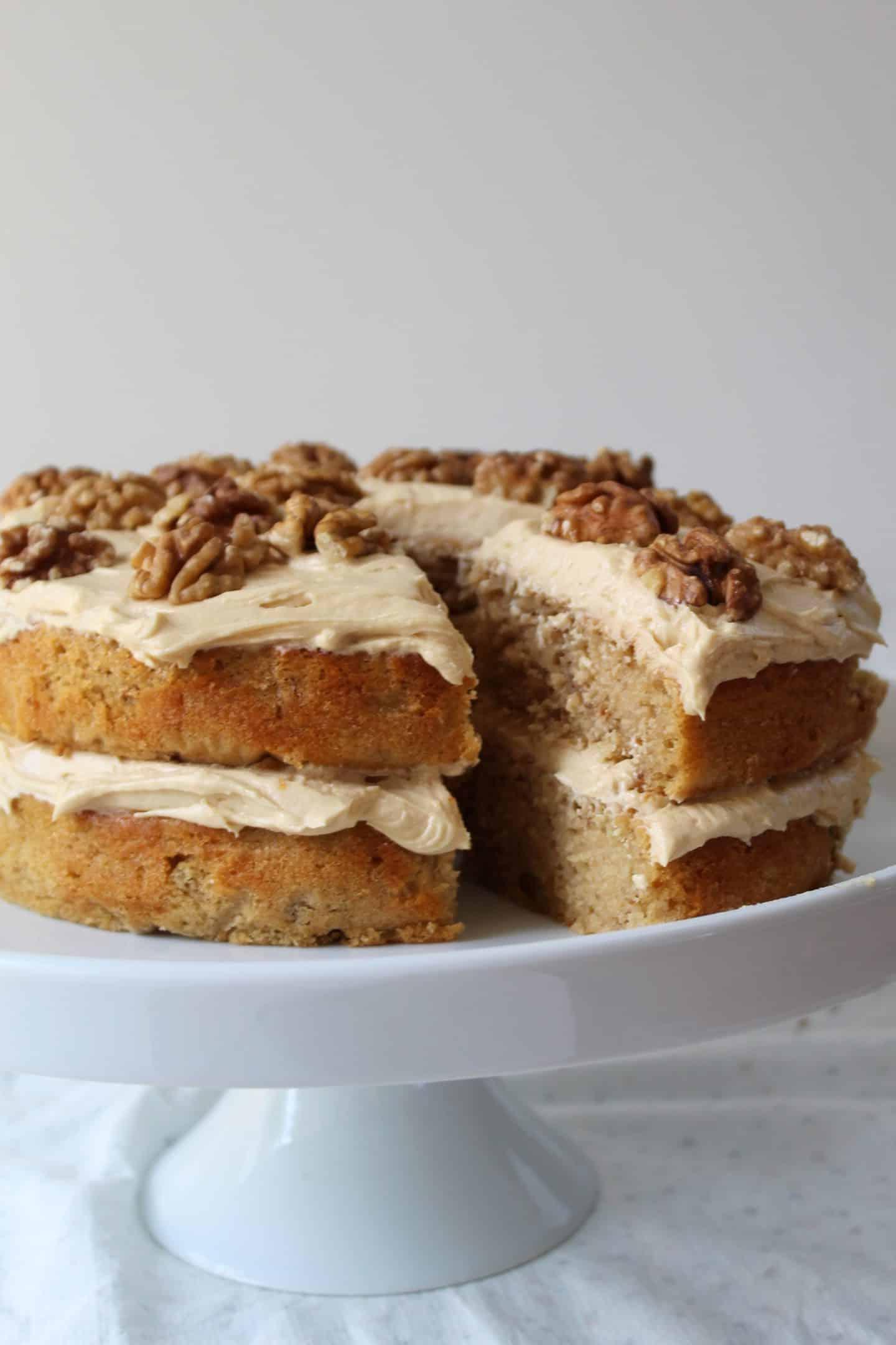 Torta al Caffè e Noci Senza Glutine 2 Una torta al caffè e noci senza glutine su un'alzata per torte.