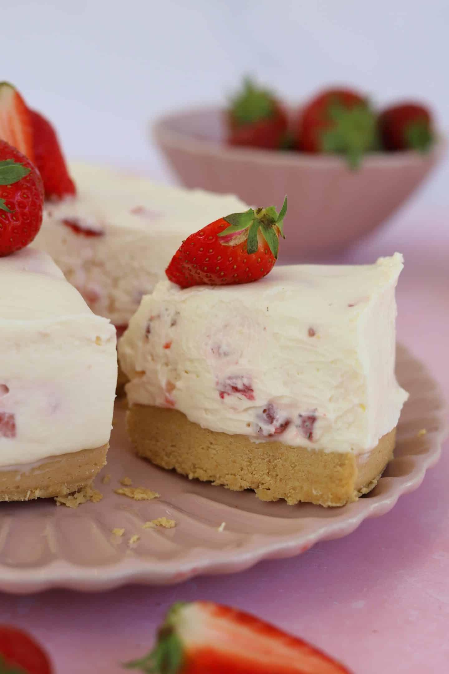Cheesecake alla fragoga senza glutine 2 Una fetta di cheesecake alle fragole senza glutine e senza cottura su un piatto.