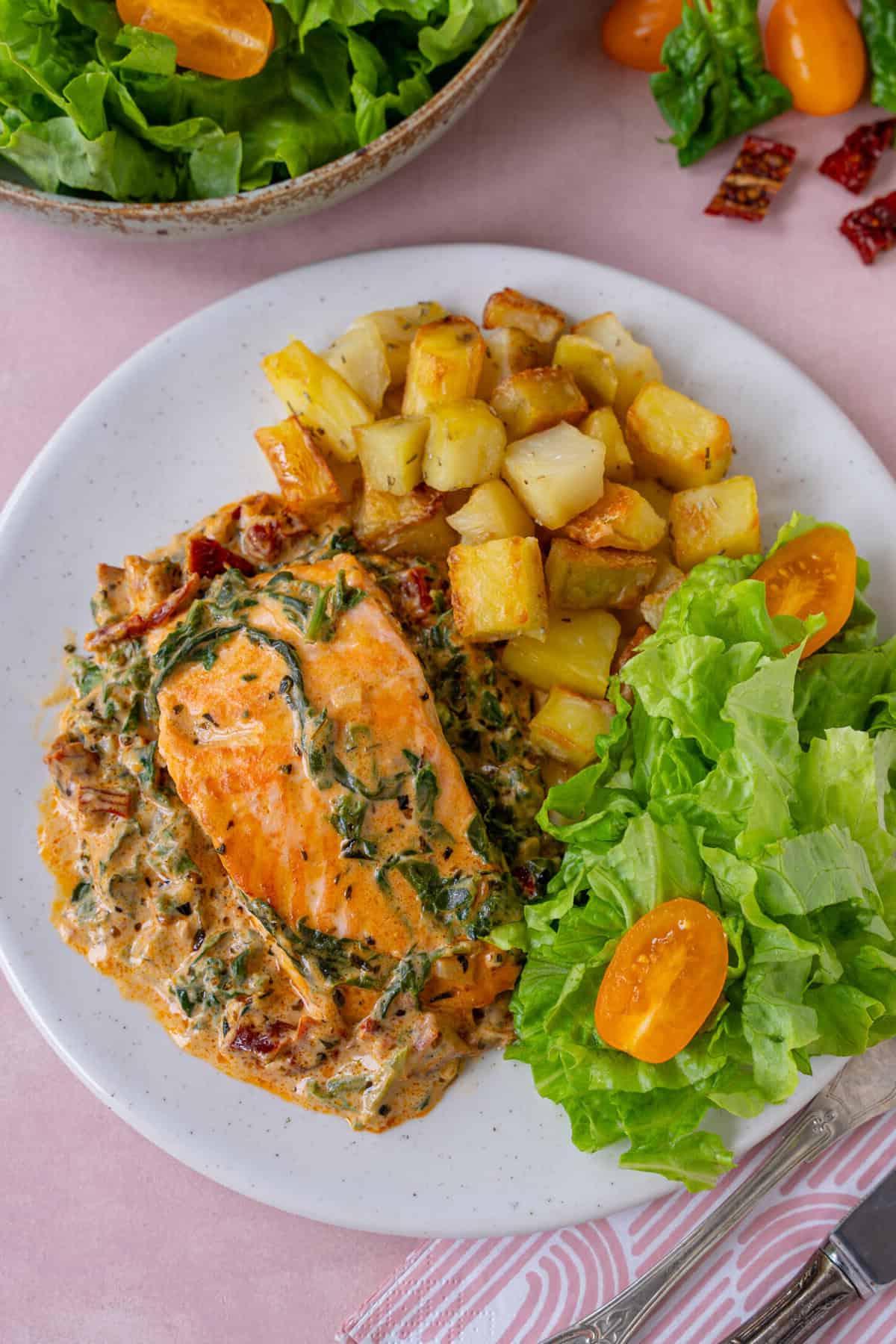 Salmone Cremoso Toscano 3 Un piatto di salmone toscano con patate parmentier e insalata.