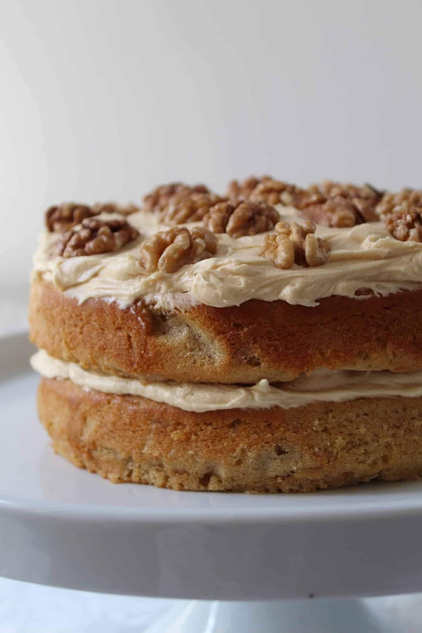 Torta al Caffè e Noci Senza Glutine 4 Una torta al caffè e noci senza glutine su un'alzata per torte.