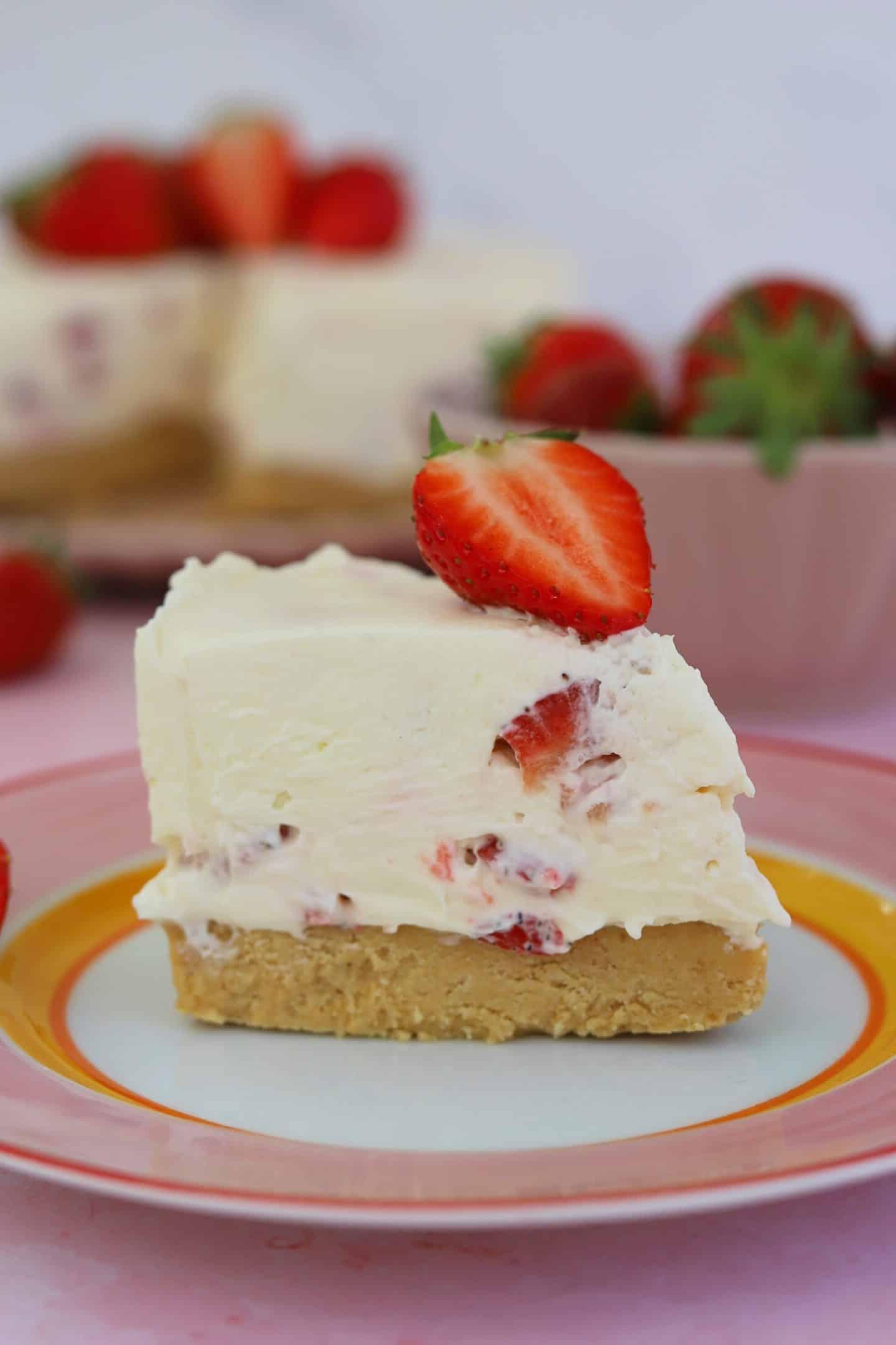 Cheesecake alla fragoga senza glutine 4 Una fetta di cheesecake alle fragole senza glutine e senza cottura su un piatto.