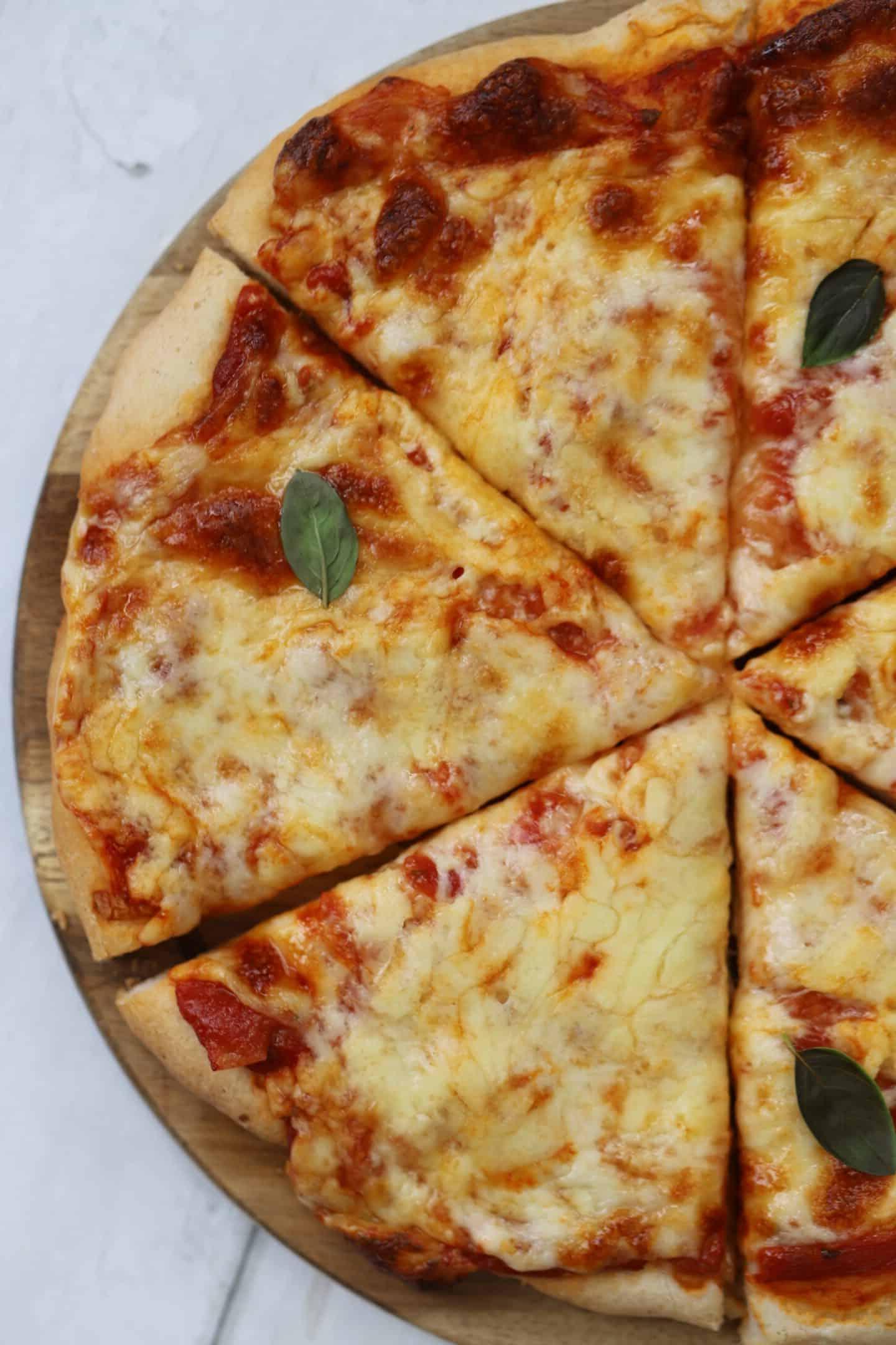Caputo Impasto per Pizza Senza Glutine 4 Una pizza al formaggio su un tagliere di legno, pronta per essere gustata.