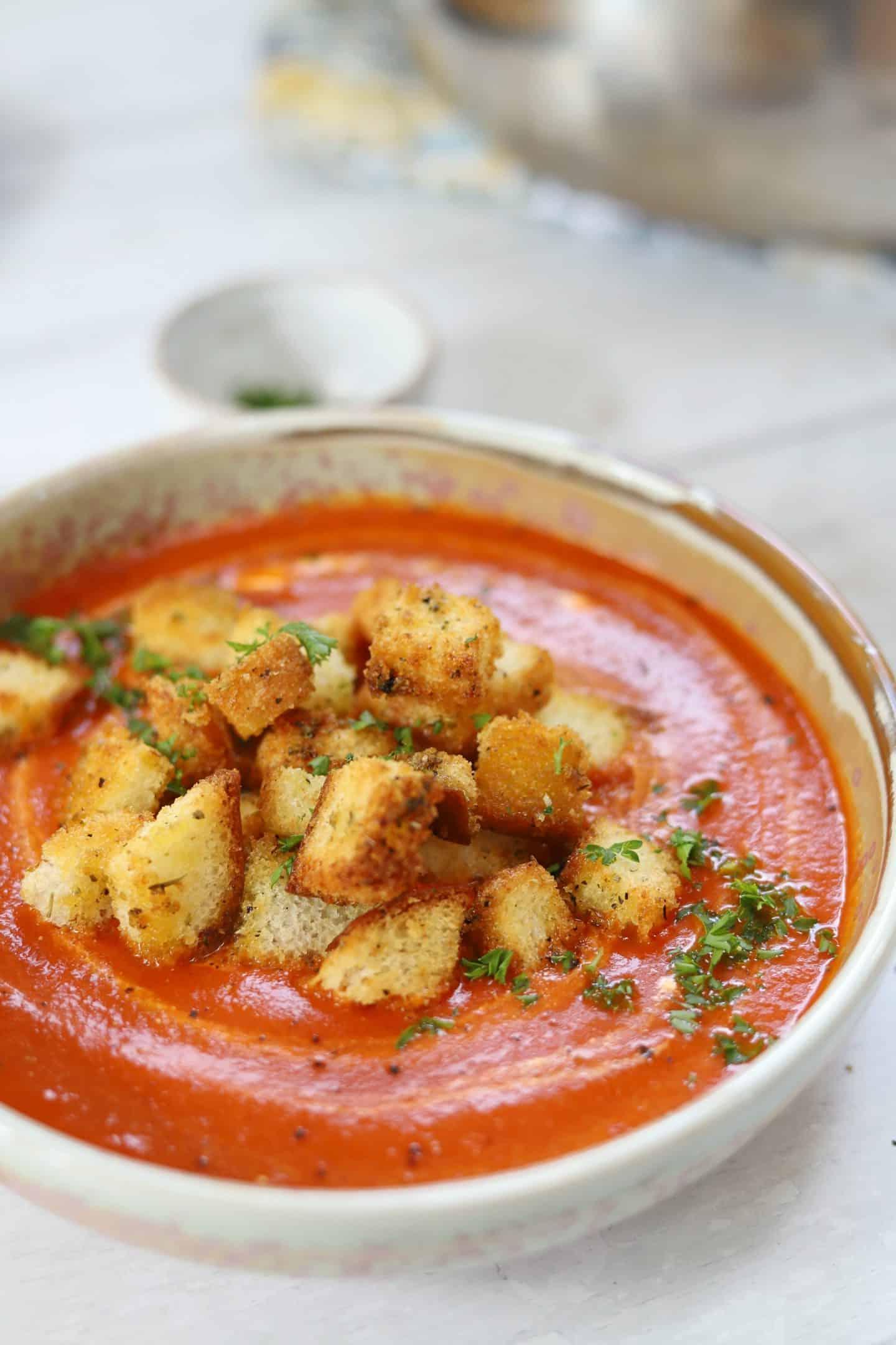 Zuppa di pomodoro senza glutine 7 Una ciotola di zuppa di pomodoro senza glutine con harissa guarnita con crostini senza glutine.