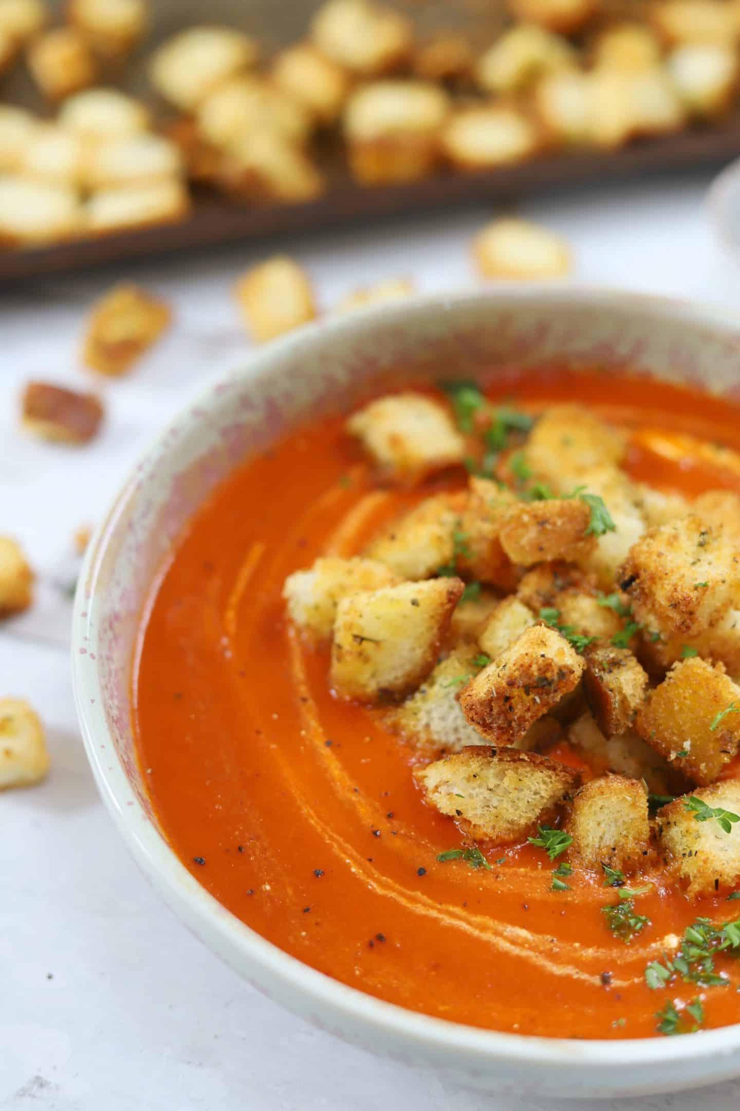 Zuppa di pomodoro senza glutine 8 Una ciotola di zuppa di pomodoro senza glutine con harissa guarnita con crostini senza glutine.