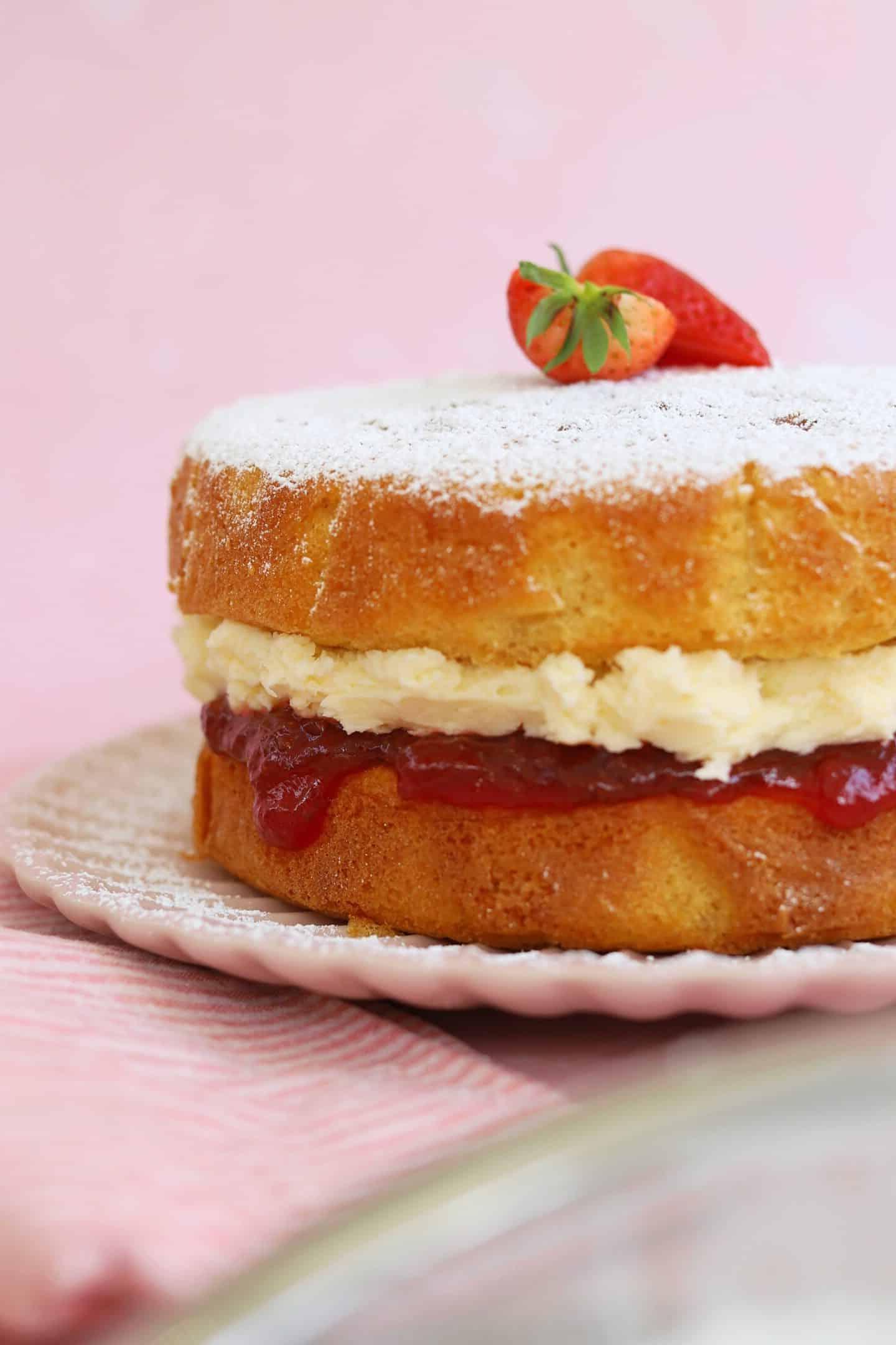 Torta Victoria Senza Glutine 8 Una fetta di Torta Victoria senza glutine con pan di Spagna chiaro, burrocrema e marmellata, seduta su un piatto, a dimostrazione della sua perfetta stratificazione.