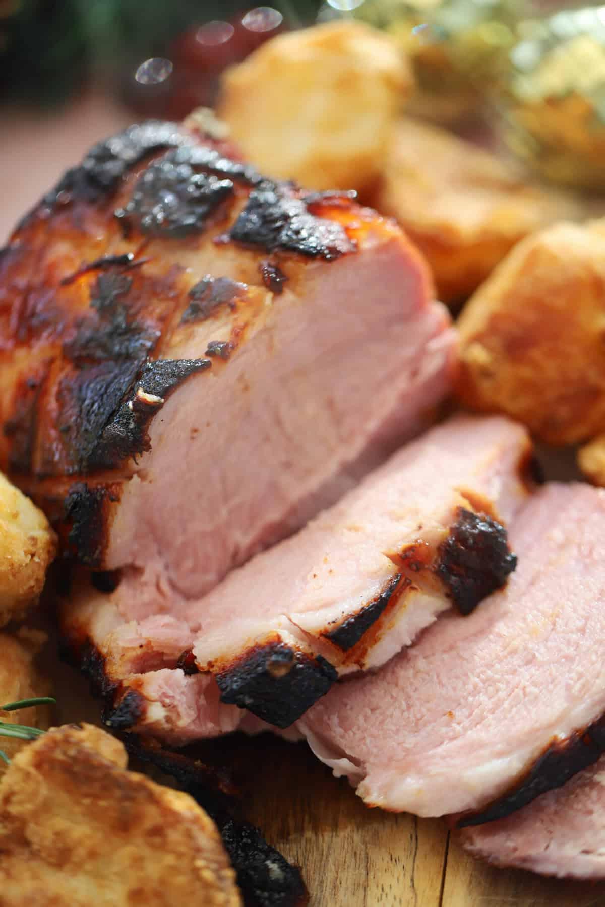Un prosciutto cotto in slow cooker su un tagliere con glassa di marmellata.