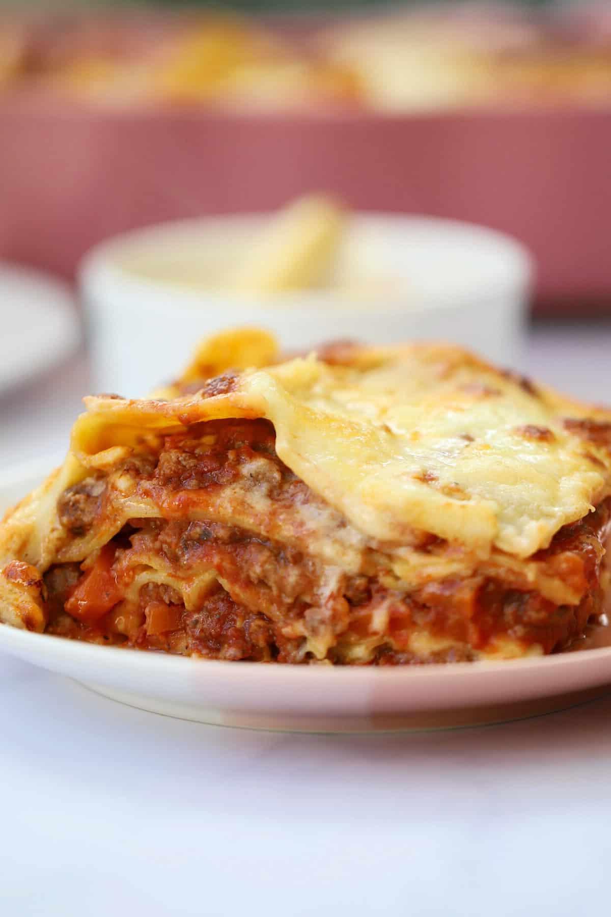 Lasagne Senza Glutine 2 Porzione ravvicinata di lasagne senza glutine su un piatto, che mostra gli strati di pasta, salsa al formaggio e ragù di carne.