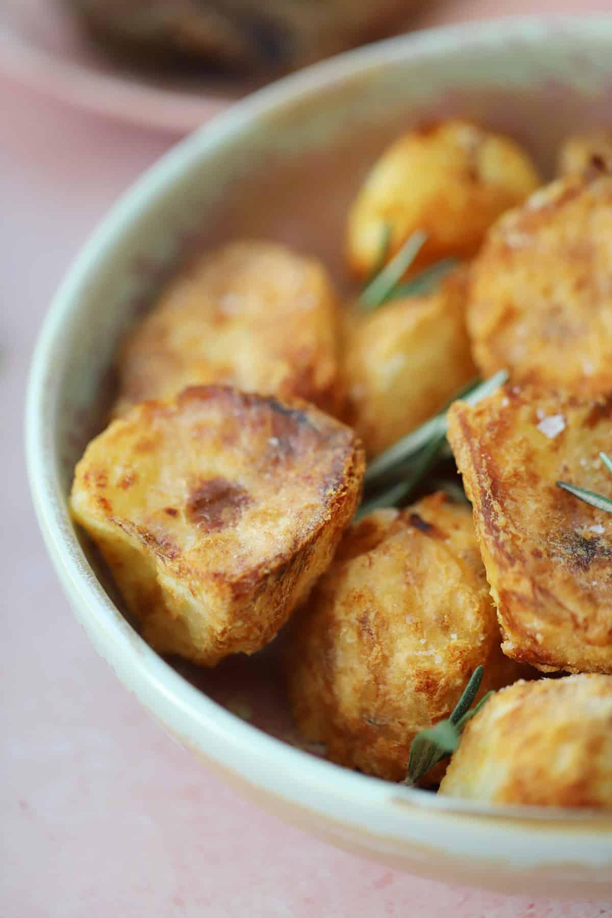 Patate Arrosto in Friggitrice ad Aria 3 Una ciotola di patate arrosto dorate e perfettamente croccanti, pronte per essere servite.