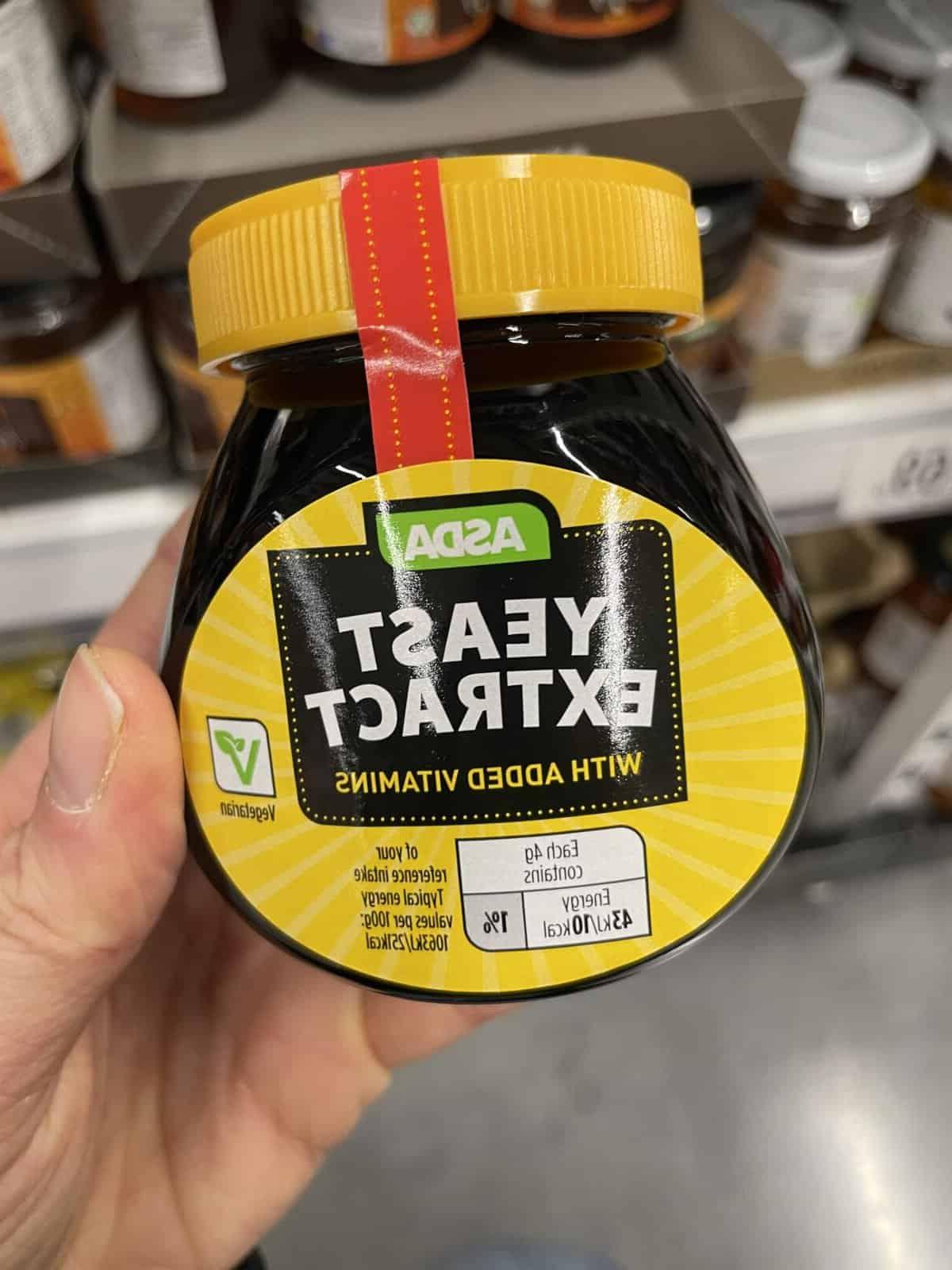**Marmite è senza glutine?** 4 Mano che tiene un vasetto di estratto di lievito Asda.